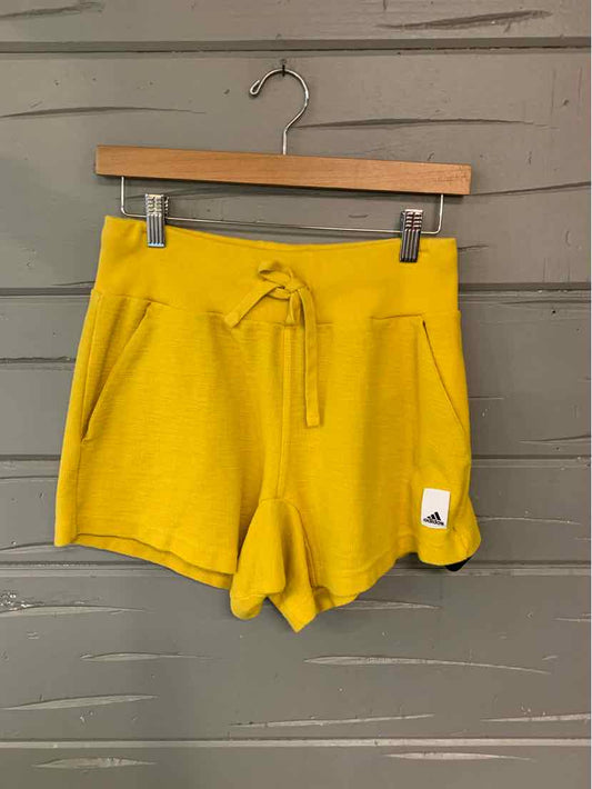 Yellow Adidas shorts with drawstring waist and front pockets, small white logo patch on hem.