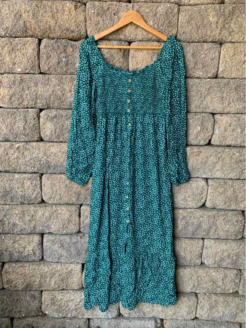 Green floral midi dress with long sleeves, square neckline, button front, and ruffled hem.