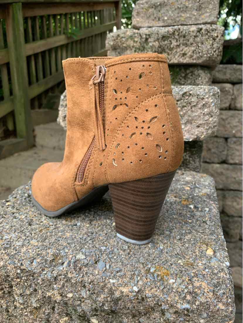 Tan suede ankle boot with stacked wooden heel and laser-cut floral patterns on the side.