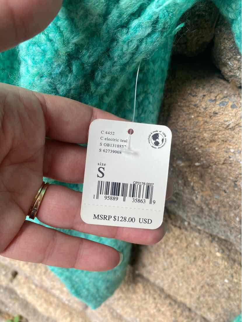 Teal knitted fabric with Free People size small price tag showing $128.00 MSRP.