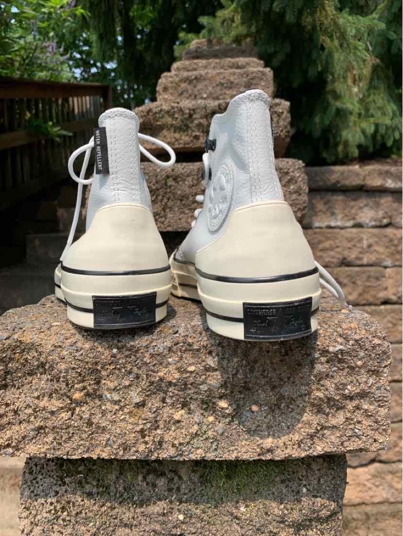 White high-top Converse sneakers with black stripe detailing and thick rubber soles, size 8.