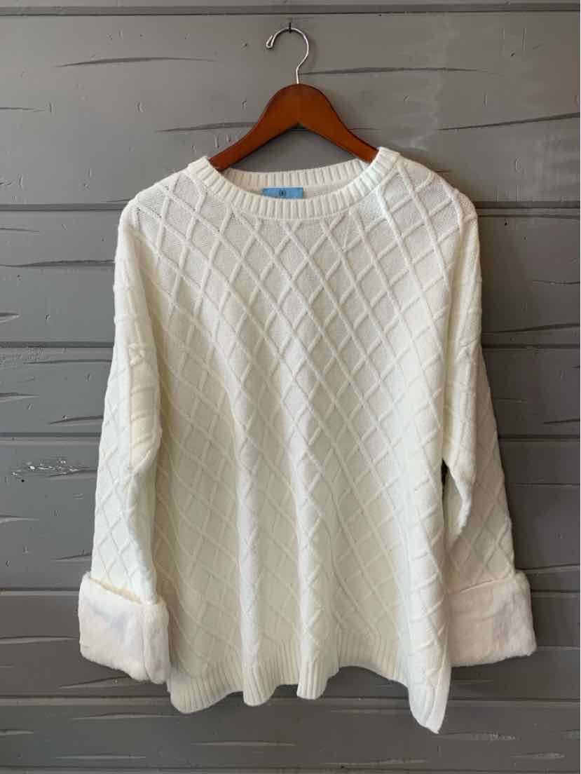 Ivory white knit sweater with a raised diamond pattern, crew neck, and wide cuffs, hanging on a wooden hanger.