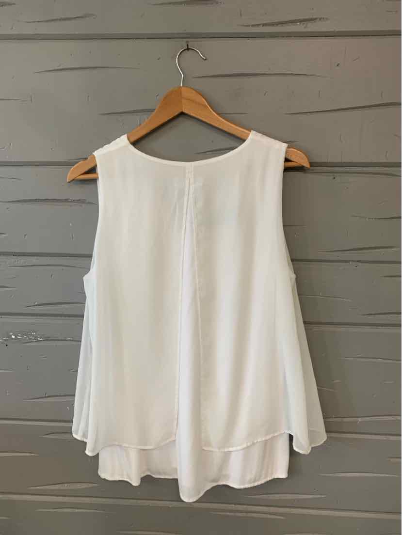 White sleeveless Calvin Klein top with a flowy, layered hem on wooden hanger.