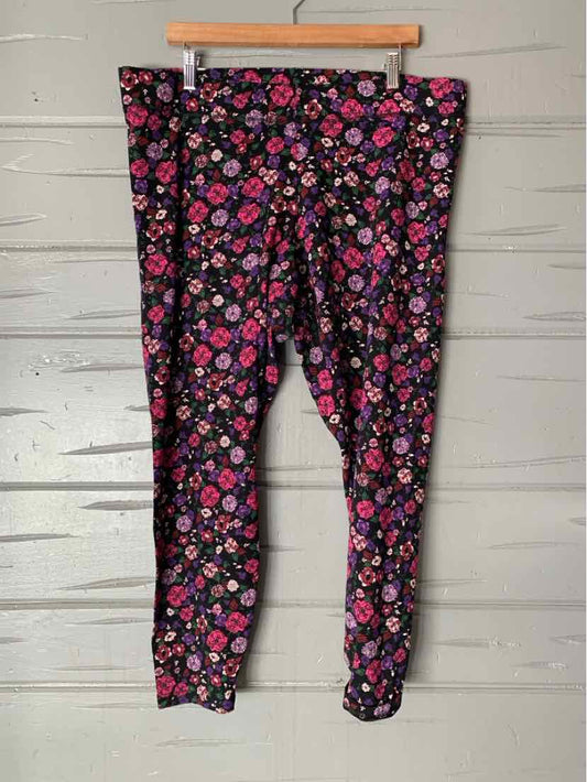 Black leggings with colorful pink and purple floral print, size 2XL, hanging on wooden hanger.