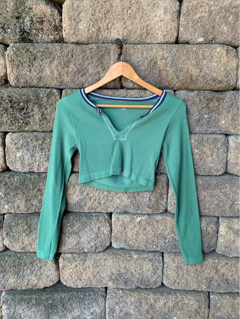 Green cropped long-sleeve henley shirt with buttoned neckline, soft lightweight fabric.