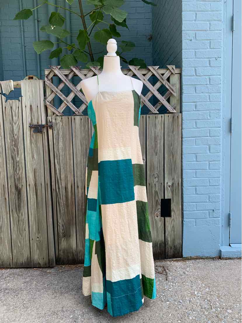 Maxi dress with wide horizontal color blocks in cream and teal, sleeveless with a fitted bodice and square neckline.