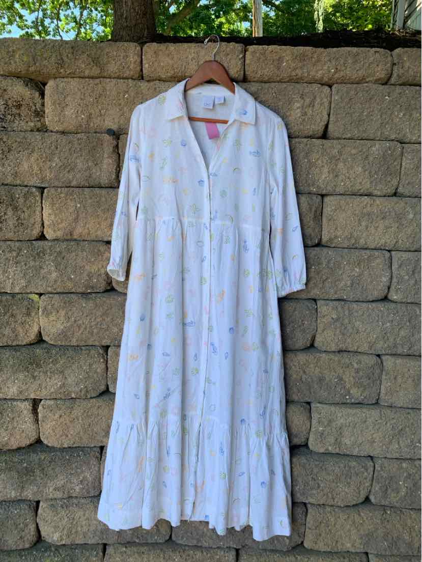 White long-sleeve maxi dress with multicolor floral print, button-down front, tiered skirt, lightweight fabric.