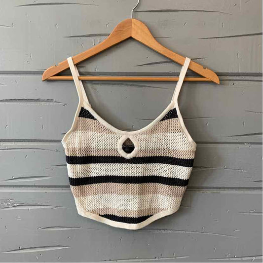Beige and black striped knit crop top with thin straps and a small front cutout hanging on wooden hanger.