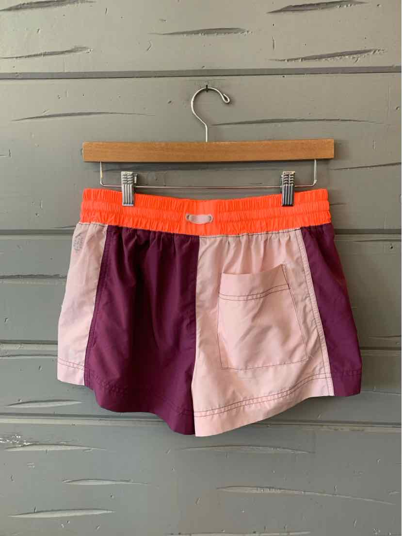 Color-blocked athletic shorts with purple front panels, light pink side pockets, and bright orange elastic waistband.
