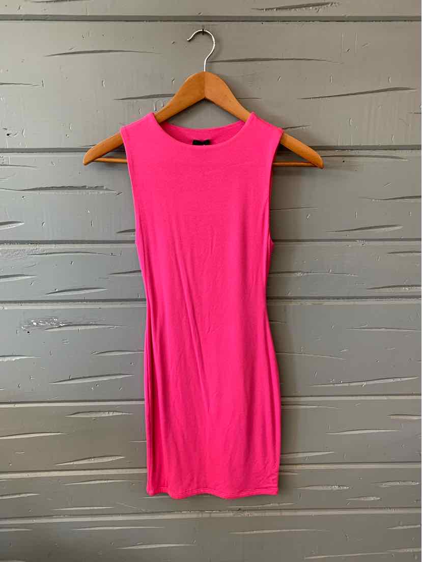 Sleeveless solid bright pink bodycon dress hanging on wooden hanger against gray textured wall.
