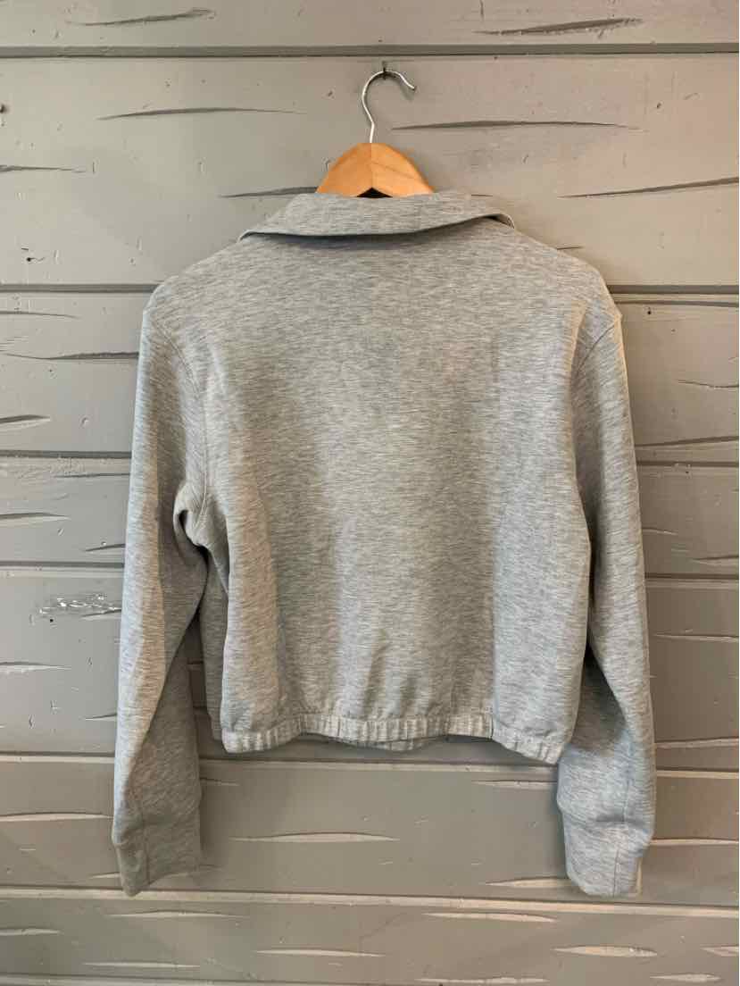 Light gray long-sleeve cropped sweatshirt with collar and elastic hem hanging on wooden hanger.