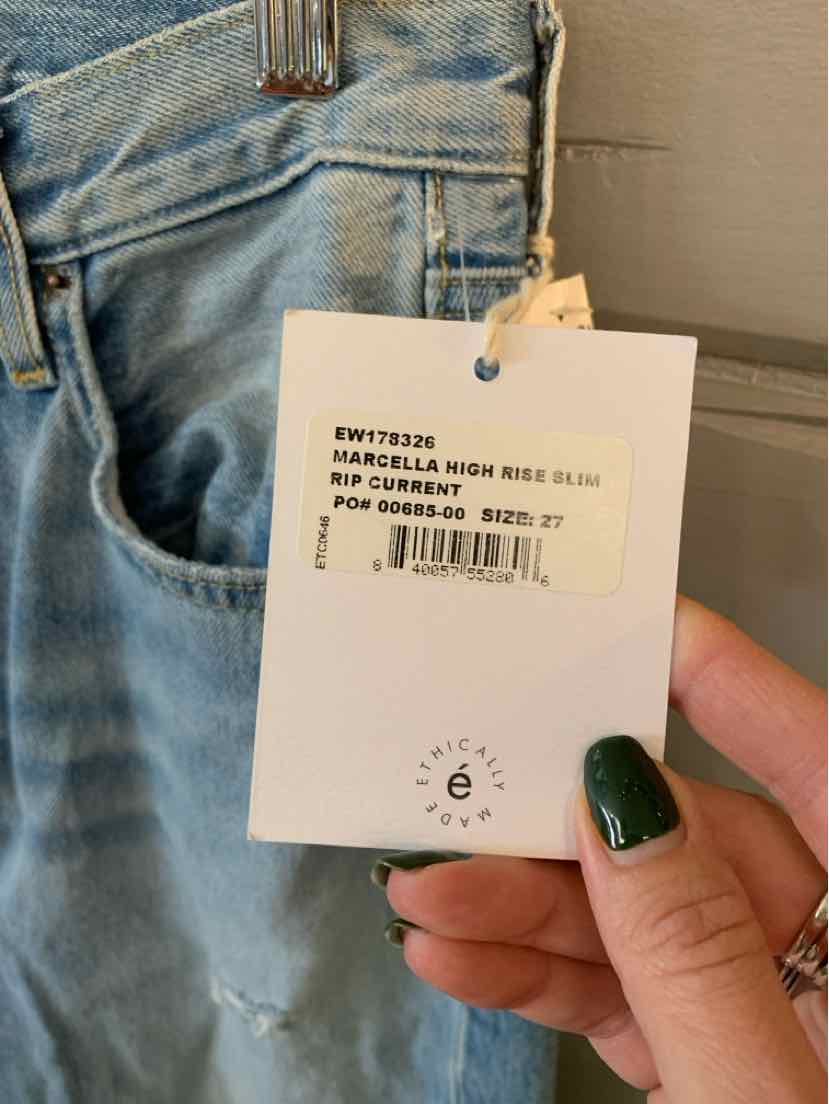 Light blue denim jeans with faded wash detail and white product tag attached at waistband.