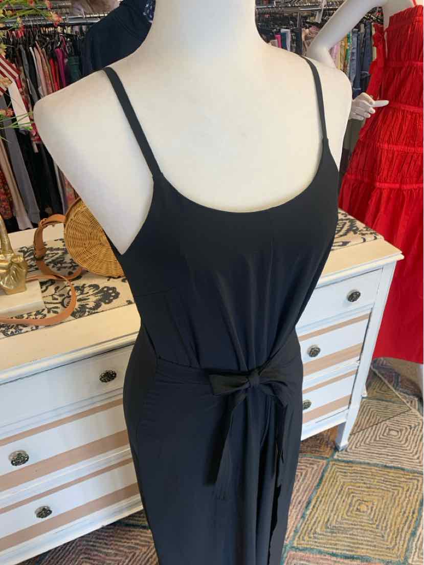 Black sleeveless dress with thin straps and waist tie belt on mannequin.