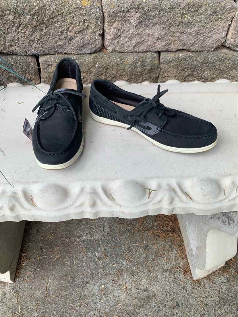 Black casual boat shoes with white soles, lace-up front, and textured fabric upper.
