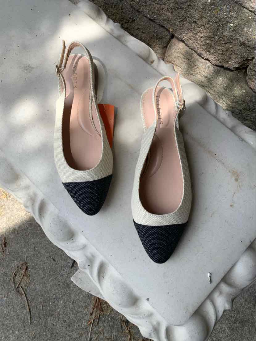 Two-tone tan and black pointed-toe slingback flats with a low heel and leather finish.