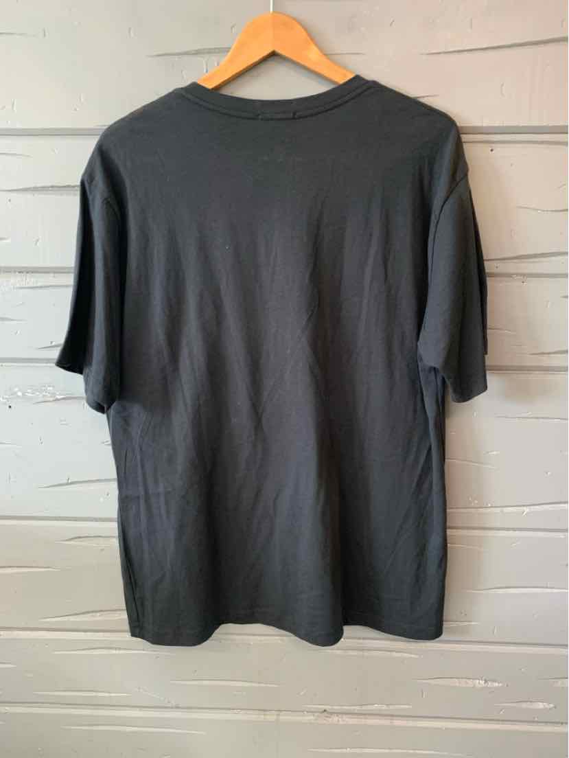 Black medium-sized short-sleeve canvas t-shirt with crew neckline hanging on wooden hanger.