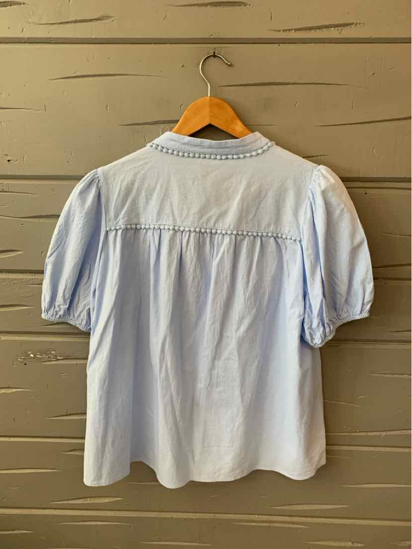 Light blue blouse with puffed short sleeves and delicate embroidered neckline, loose fit.