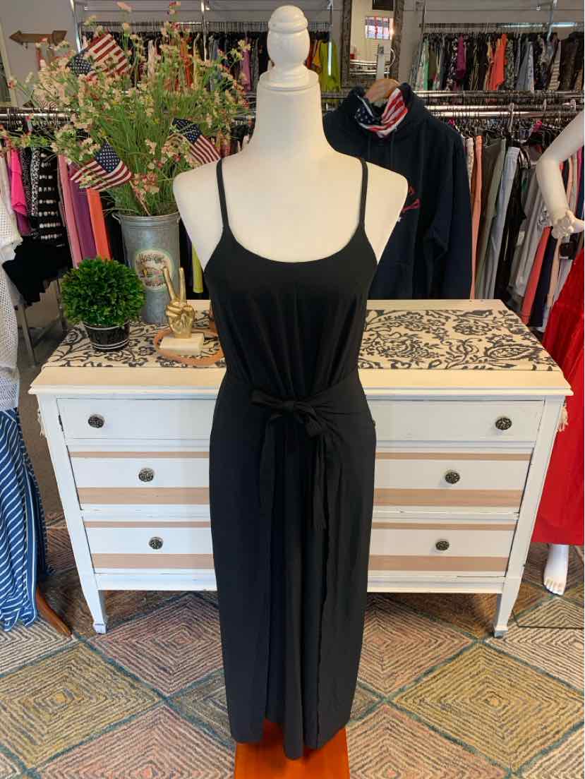 Black sleeveless jumpsuit with adjustable straps and waist tie on mannequin.