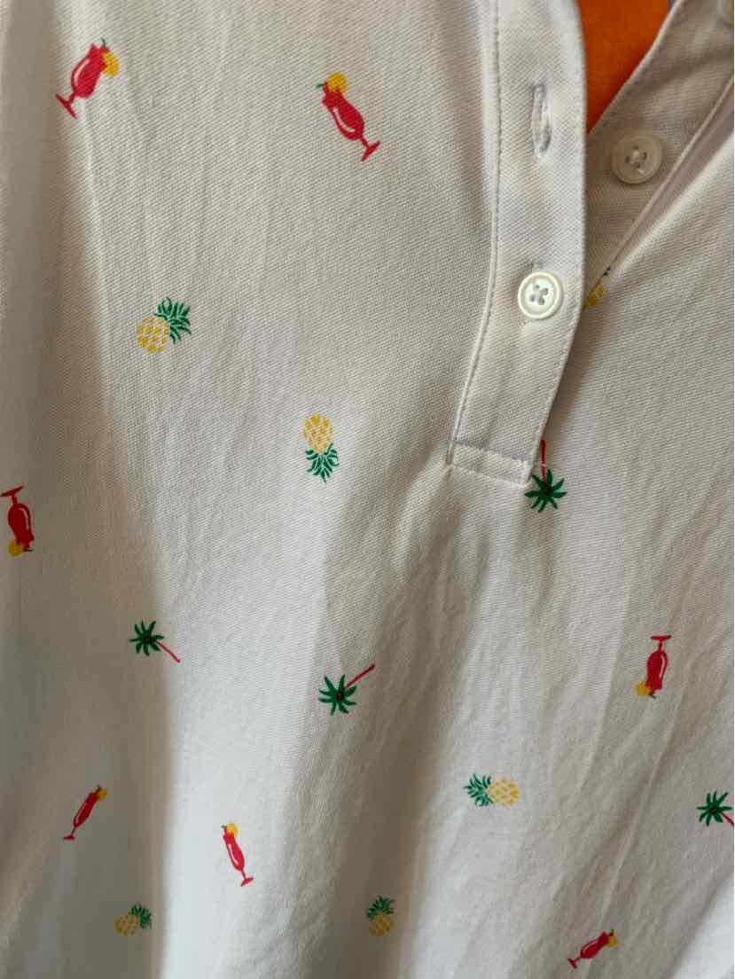 White cotton polo shirt with small colorful tropical icons embroidered, including pineapples, palm trees, and red parrots.