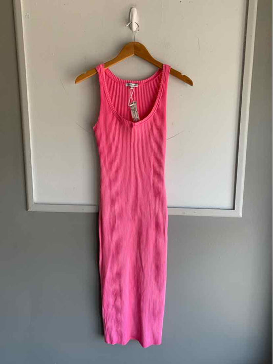 Sleeveless pink ribbed cotton tank dress with scoop neckline hanging on wooden hanger.