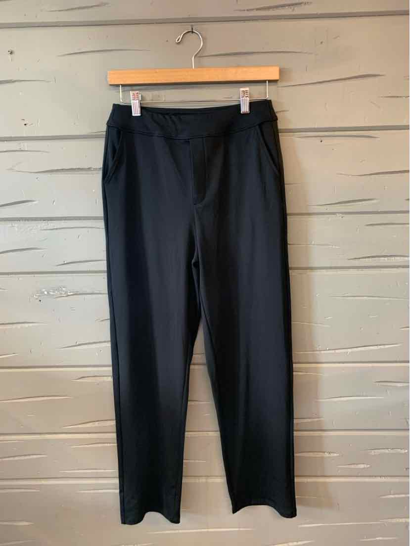 Black slim-fit pants with a straight leg and elastic waistband hanging on a wooden hanger.