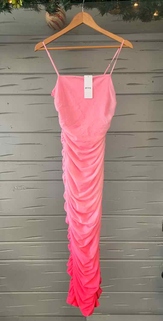 Pink ruched midi dress with thin spaghetti straps hanging on wooden hanger.