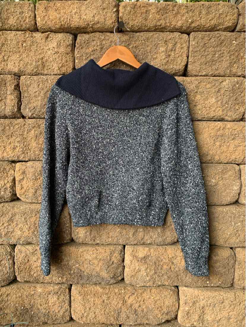 Gray knit sweater with wide navy turtleneck collar, long sleeves, and fitted waist.