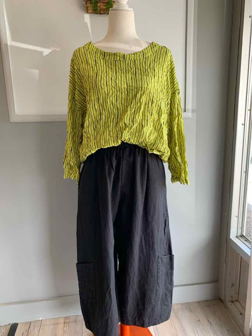 Light green textured long-sleeve crop top paired with high-waisted wide-leg black pants.