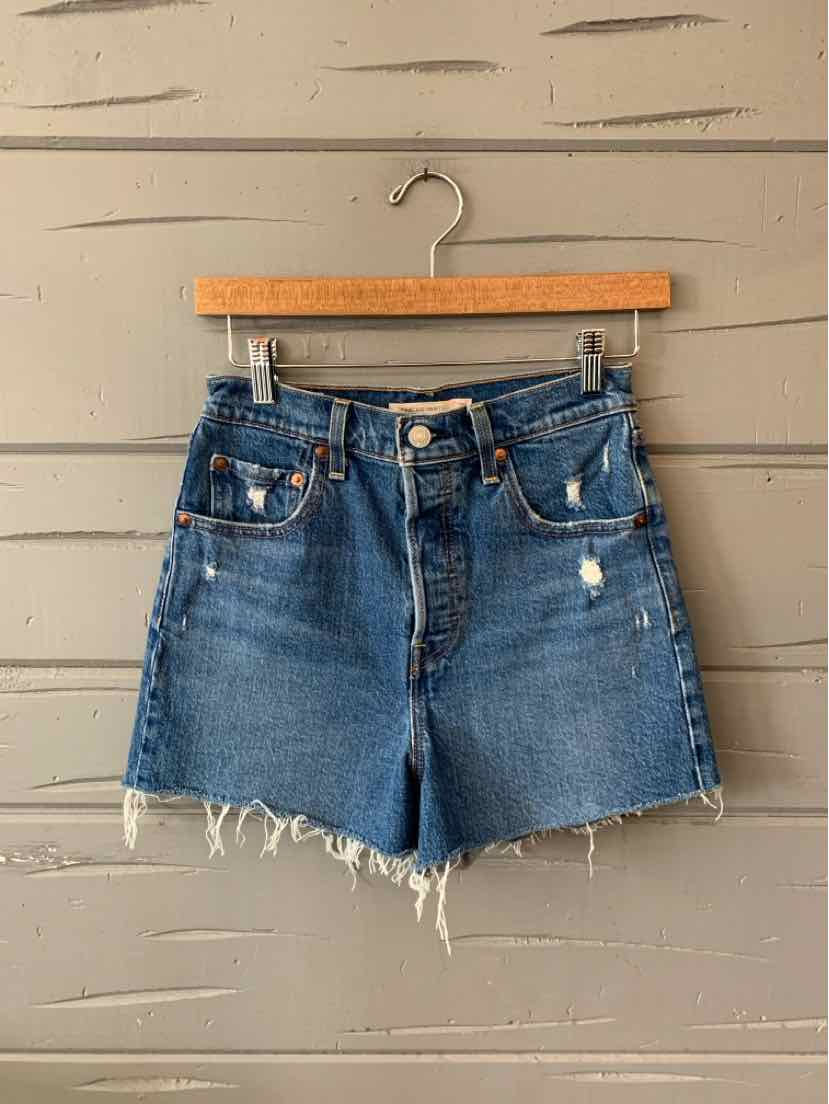 Blue denim Levi's shorts with frayed hems, front button closure, and slight distressing.