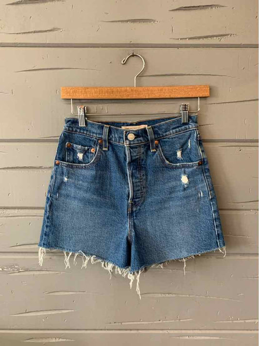 Blue denim Levi's shorts with frayed hems, front button closure, and slight distressing.
