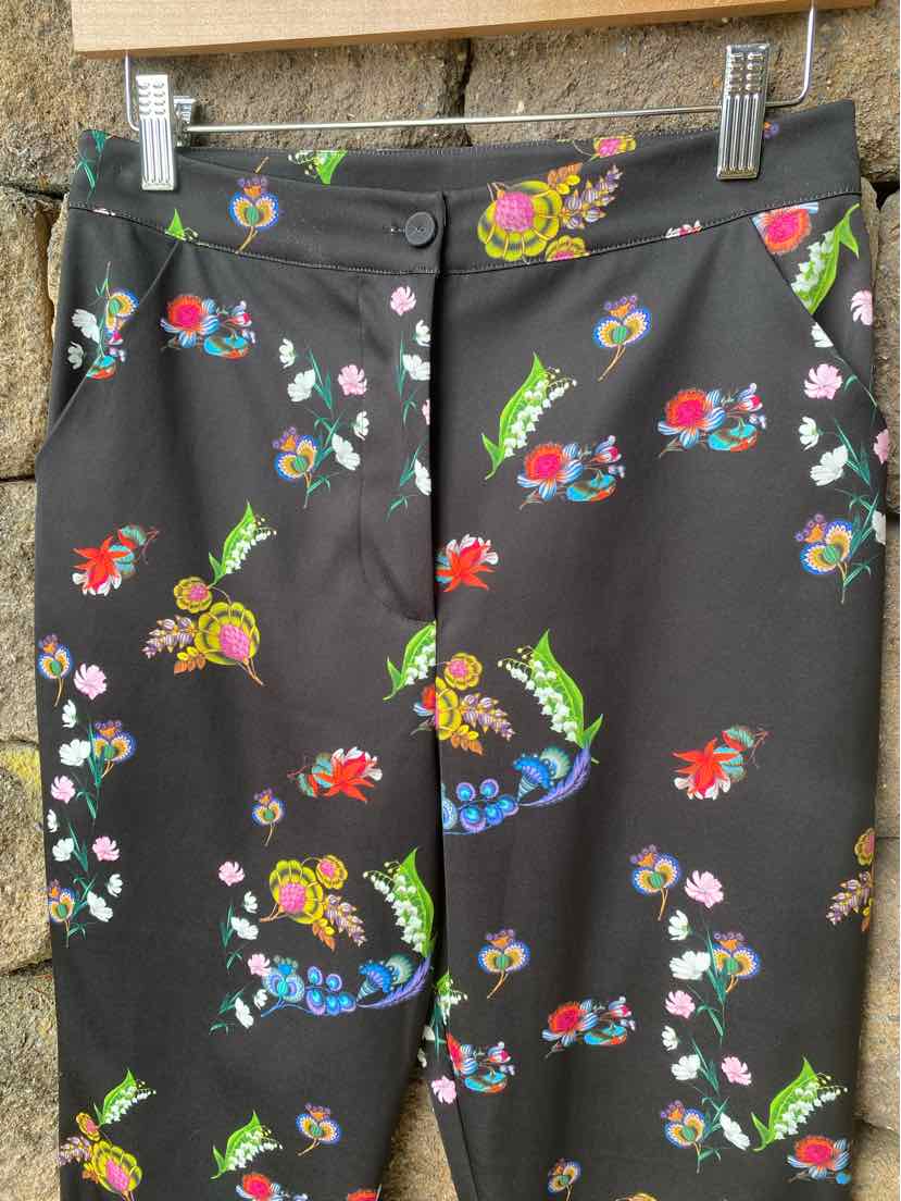 Black skirt with colorful floral print, fitted waist, and straight cut in size 4.