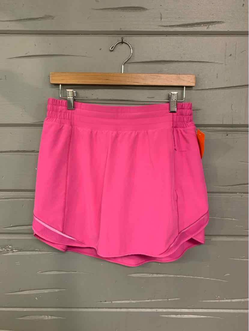 Bright pink athletic shorts with an elastic waistband and reflective trim near the hem.