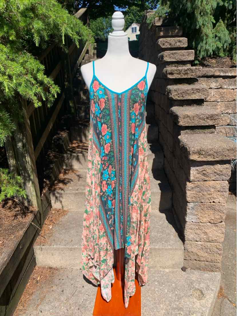 Flowy sleeveless dress with teal, coral, and cream floral pattern and thin straps.