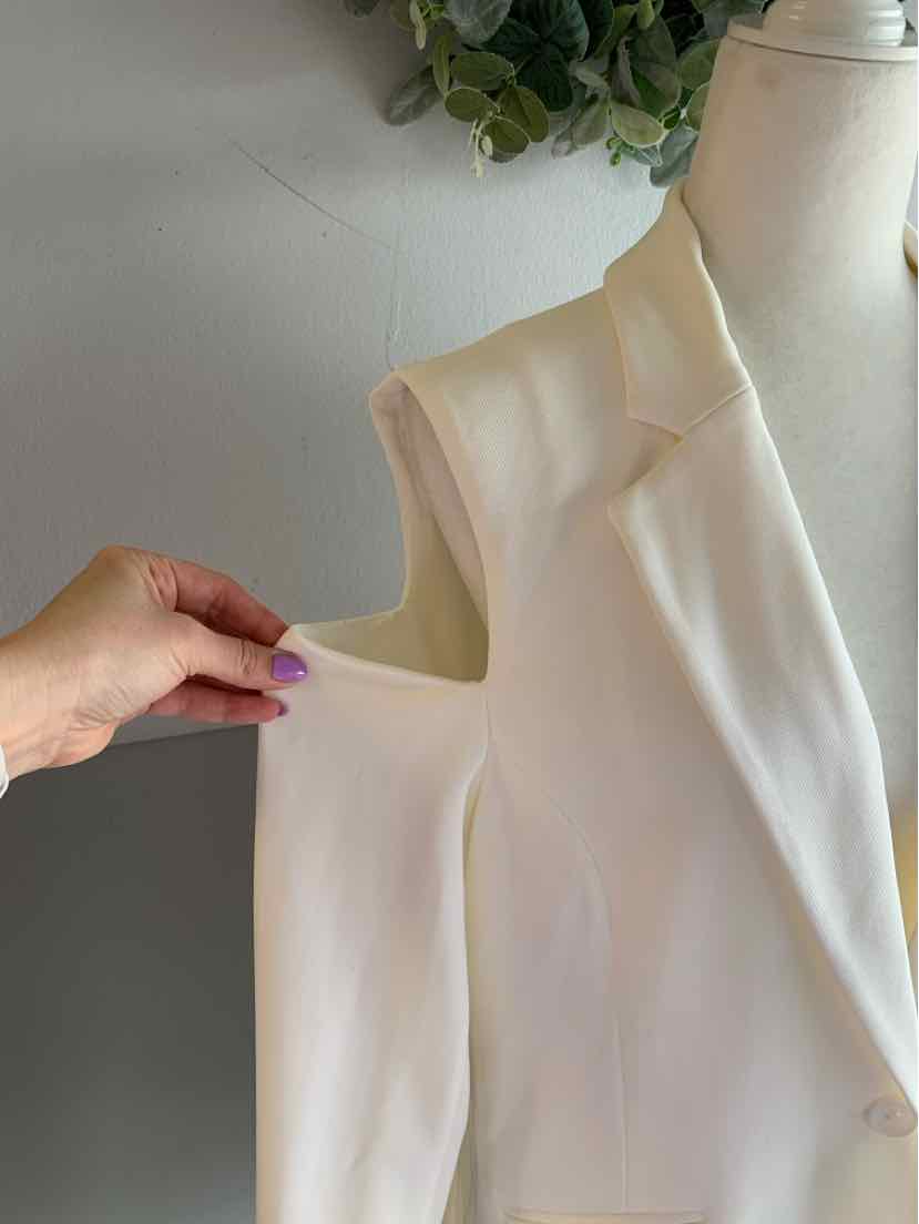 Cream sleeveless blazer with notch lapels and single-button closure on mannequin.