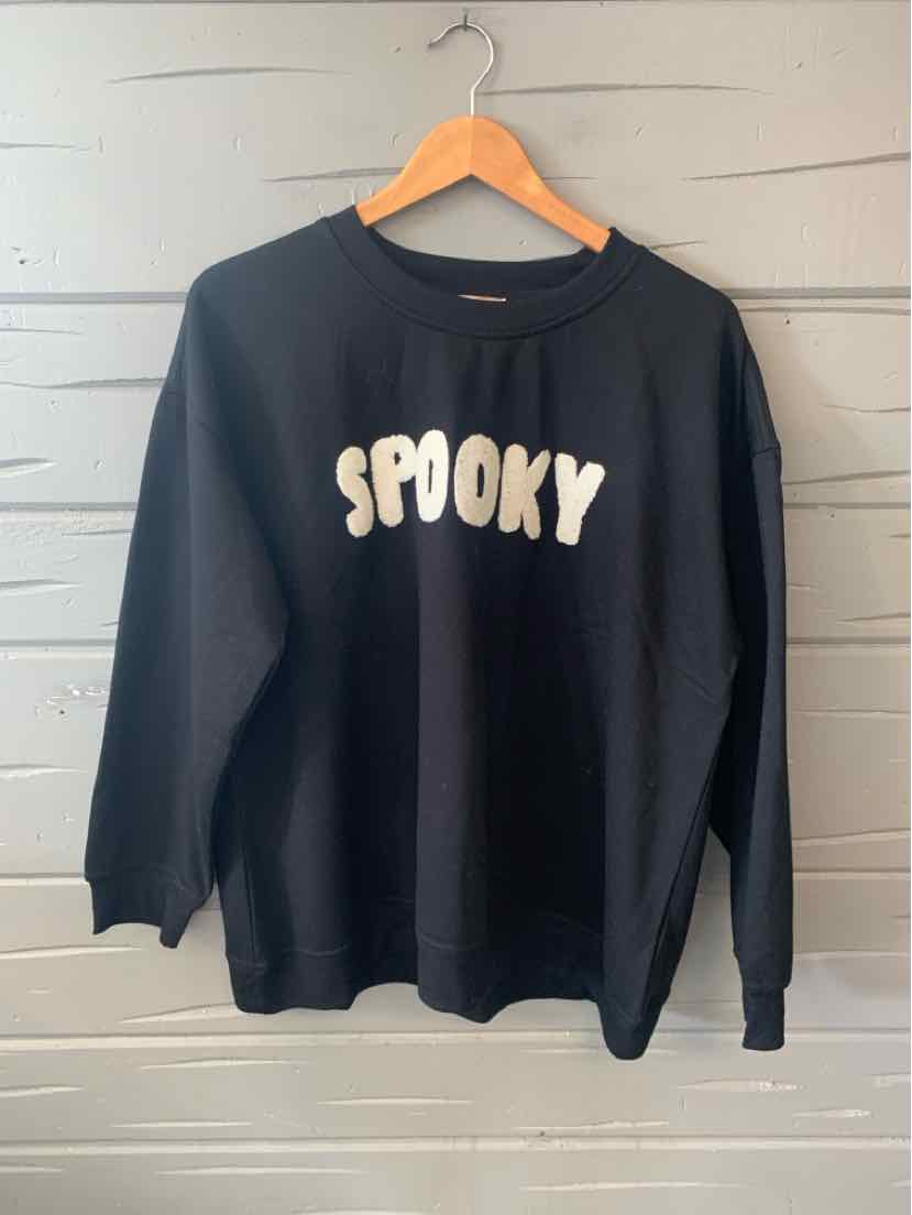 Black long-sleeve sweatshirt with white "SPOOKY" text in bold, rounded font on front.