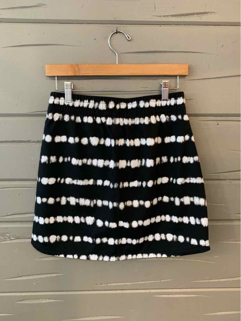Black and white tie-dyed mini skirt with horizontal stripes on wooden hanger.