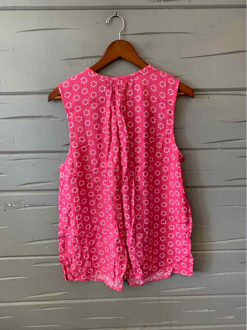 Sleeveless pink blouse with white floral pattern and pleated back detail hanging on wooden hanger.