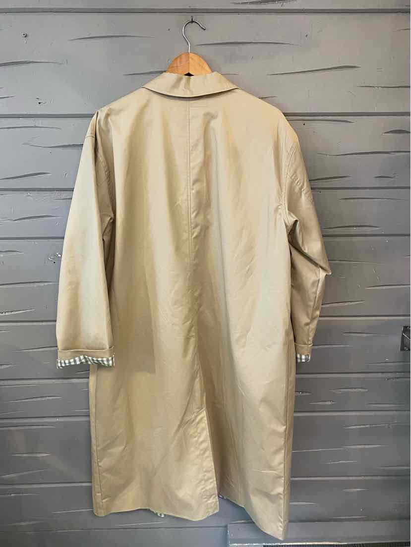 Tan long coat with three-quarter sleeves and a collar, hanging on wooden hanger against gray wood plank background.