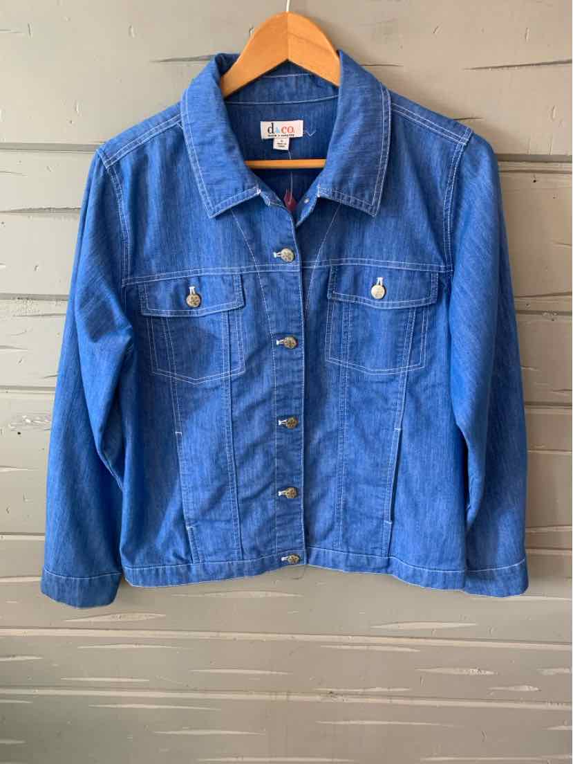 Classic blue denim jacket with button front, two chest pockets, and long sleeves on wooden hanger.