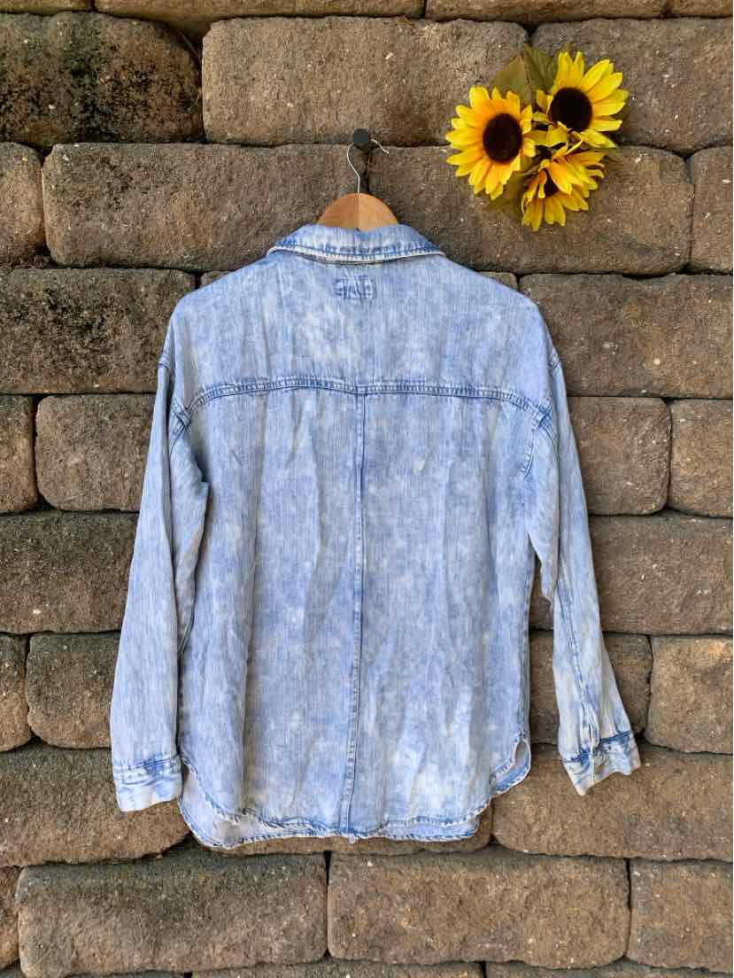Light blue denim long-sleeve shirt with button cuffs and a classic collar, shown from the back.
