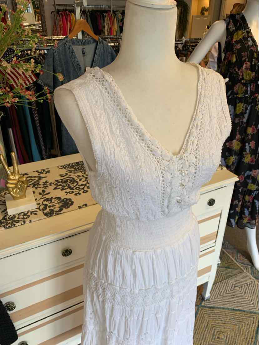 White sleeveless dress with lace detailing, deep V-neckline, and cinched waist in medium size.