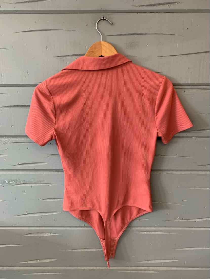Rust-colored short-sleeve bodysuit with collar and fitted silhouette hanging on wooden hanger.