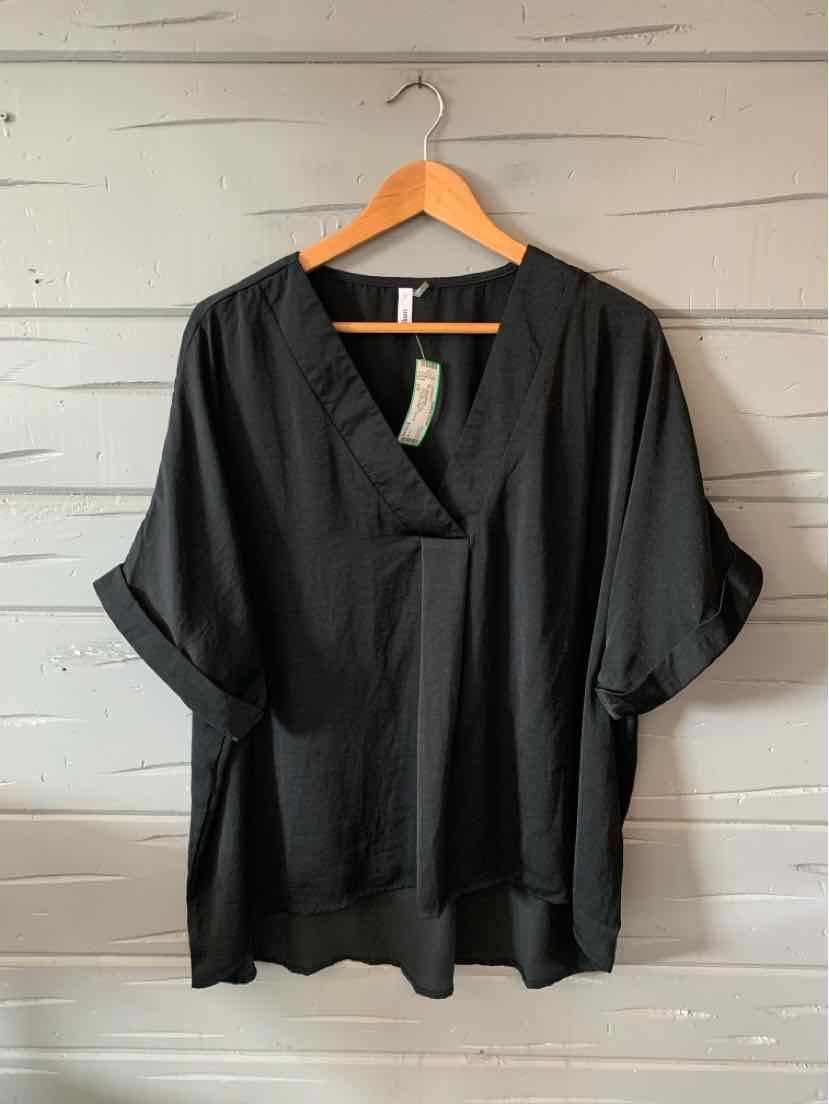 Black oversized V-neck tunic with rolled sleeves and relaxed fit on wooden hanger.