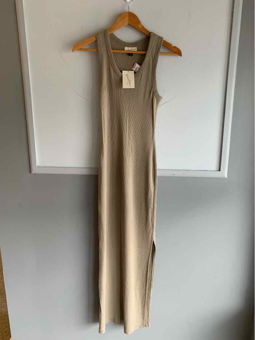 Sleeveless tan knit maxi dress with scoop neckline and form-fitting silhouette.
