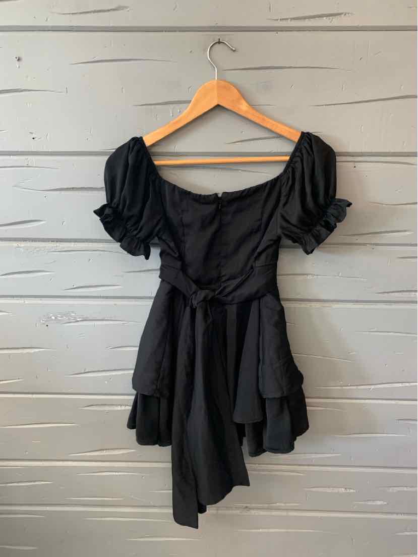 Black short-sleeve dress with puffed sleeves, square neckline, button front, and asymmetrical hem.