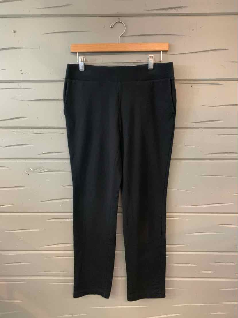 Black straight-leg pants with a slim fit and elastic waistband hanging on wooden hanger.