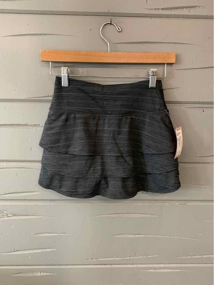 Charcoal gray athletic skirt with tiered ruffle layers and a wide elastic waistband in size XXS.