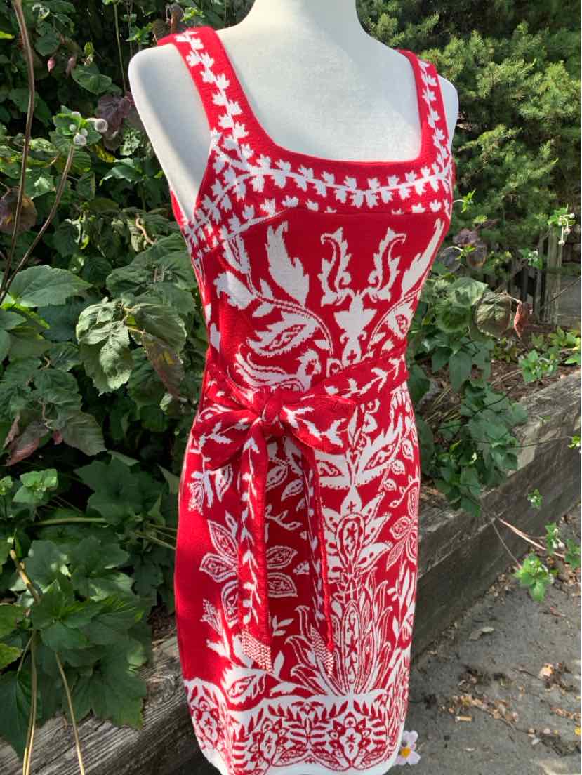 Red sleeveless dress with white paisley and floral print, square neckline, and waist tie belt.