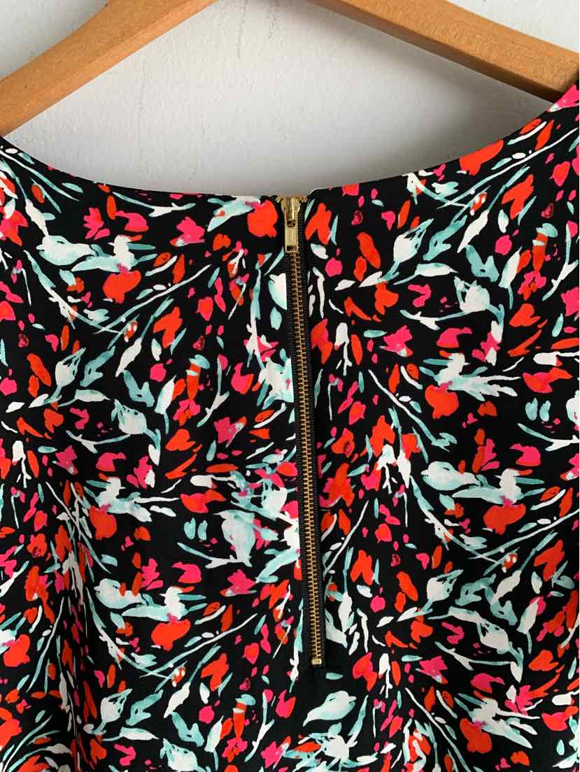 Black floral dress with red, pink, and white flowers and a center back zipper detail.