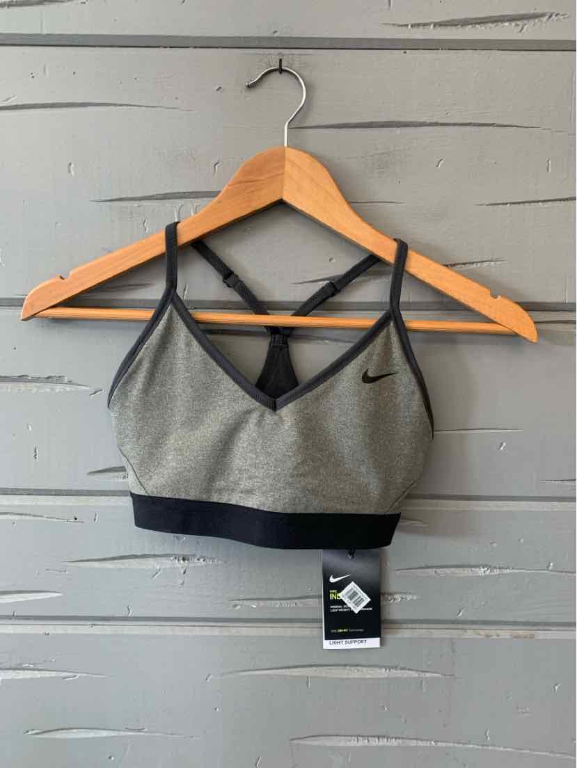 Gray Nike sports bra with black adjustable straps and black elastic band at the bottom, lightweight fabric.